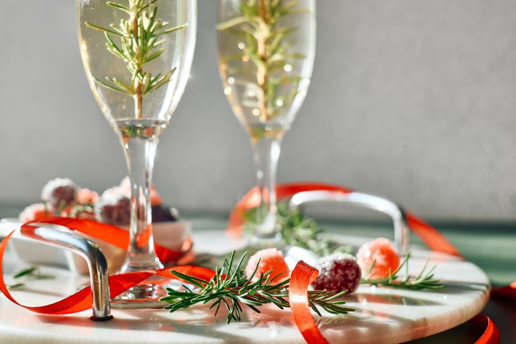 Christmas cocktail with sparkling wine, rosemary and cherry. Winter holidays champagne drink